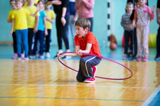 Child in the gym. A schoolboy in a physical education lesson. Relay race in elementary school. The boy goes in for sports. Children's training. Sports Day.