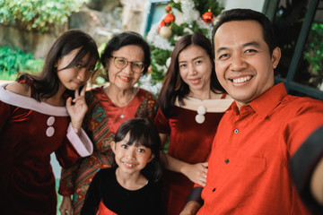 big family selfie on christmas day. asian people take picture using mobile phone