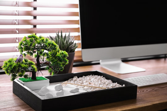 Modern workplace with beautiful miniature zen garden and computer in room