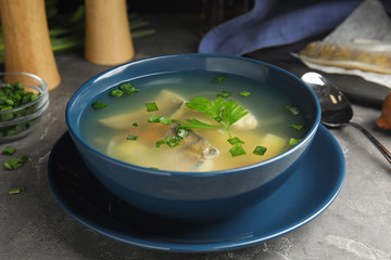 Delicious fish soup served on grey table, closeup