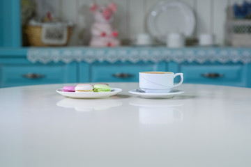 Delicious macaroons and cappuccino on a large bright table in a cozy coffee shop