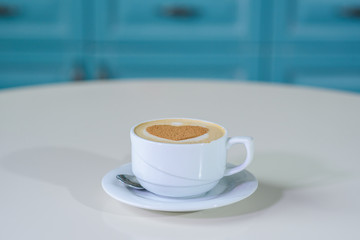 Delicious cappuccino on a large bright table in a cozy coffee shop
