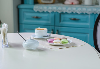 Delicious cappuccino and macaroons prepared on a table for a guest