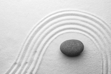 Fototapeta na wymiar Grey stone on sand with pattern, top view. Zen, meditation, harmony