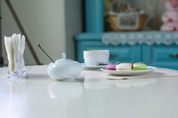 Delicious cappuccino and macaroons prepared on a table for a guest