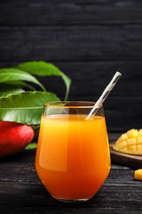 Fresh delicious mango drink on wooden table