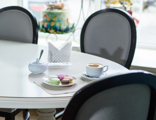 Delicious cappuccino and macaroons prepared on a table for a guest