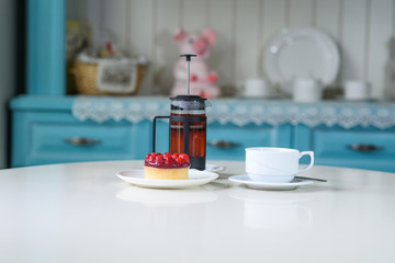 Delicious berry tea and tarte with raspberries on a table in a cozy coffee shop