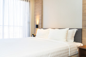 Fototapeta na wymiar White comfortable pillow on bed decoration interior