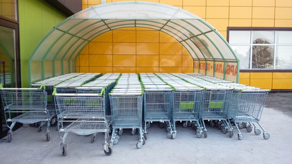 A pile of supermarket trolleys under a canopy