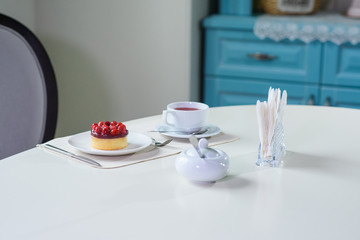 Delicious berry tea and tarte with raspberries prepared on a table for a guest in a cozy cafe