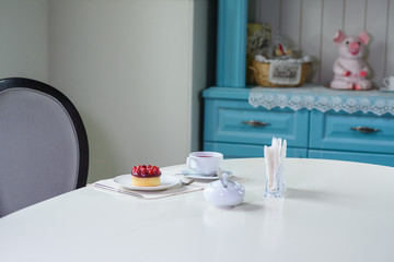 Delicious berry tea and tarte with raspberries prepared on a table for a guest in a cozy cafe
