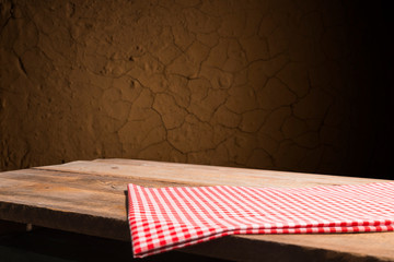 Empty wooden deck table with tablecloth over bokeh background