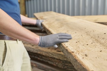 Carpenters hands with plank wood at carpentry woodworking workshop