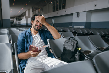 The man is very upset in the waiting room at the gate to the airport.