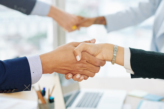 Close-up image of entrepreneurs shaking hands and entroducing themselves before discussing important issues at meeting