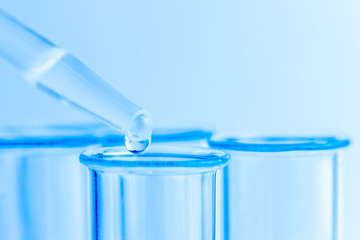 Science laboratory test blue tubes, macro flask equipment. Chemical dropper