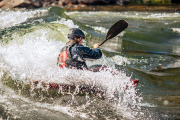 Whitewater kayaking, extreme sport rafting. Guy in kayak sails mountain river