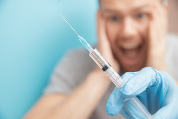 Man is afraid of nurse. Fear of syringe injections and vaccinations doctor appointment