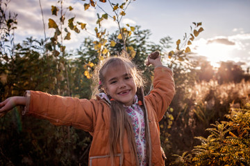 A happy girl without allergy having fun with seed hair in the field of cattails