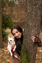 Image of a girl and her Chihuahua dog in an autumn park