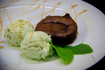 Chocolate fondant with pistachio ice cream on black background