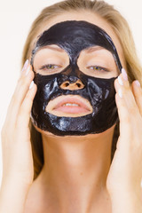 Girl with dried peel-off black mask on face