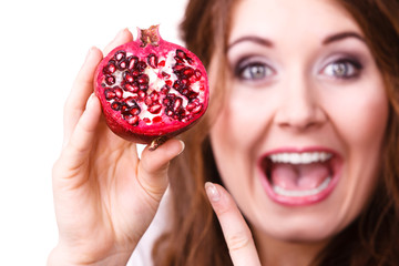 Cheerful woman holds pomegranate fruits, isolated