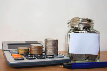 Stack coins on the calculator and money jar with space to put text.