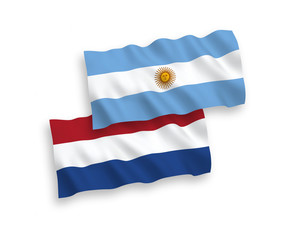 National vector fabric wave flags of Argentina and Netherlands isolated on white background. 1 to 2 proportion.