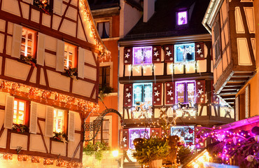 Colmar christmas decoration on streets and old houses. Holiday illumination on buildings.