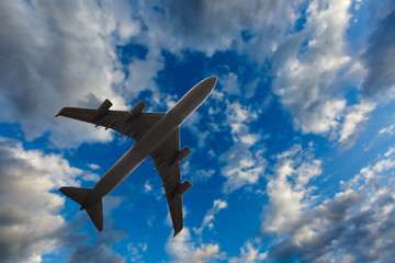 Airplane close-up on a background of blue sky with cirrostratus clouds. Bottom view