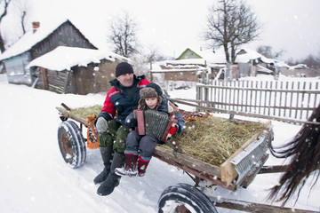 The village child and grandfather ride a horse-drawn cart. Russian rural people lived. A boy with a...