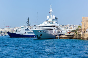Fototapeta na wymiar A modern syperyacht in the port on sunny day, Malta