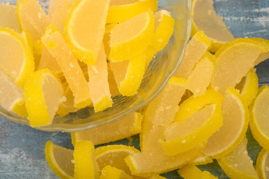 Marmalade lemon slices on wooden background. Sweet dessert. Close up.