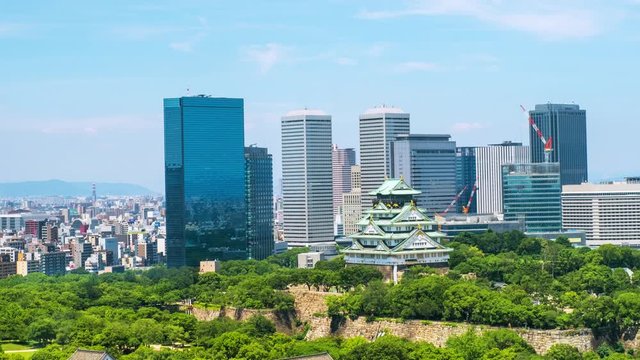 Osaka, Japam. Aerial view of Castle Park in Osaka, Japan with modern skyscrapers at the background. Time-lapse of moving clouds during the hot day with car and people traffic , zoom in
