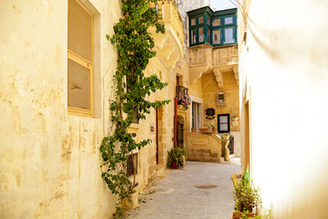 Fototapeta na wymiar An empty narrow street with traditional Maltese architecture