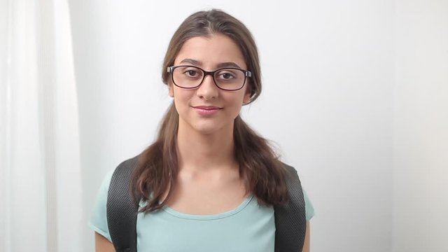 Portrait of a beautiful Indian young female student with glasses with textbooks.