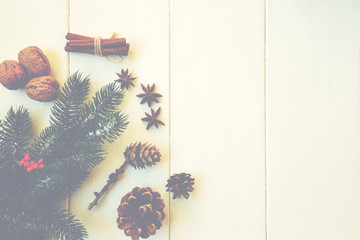 Christmas composition. Fresh fir tree branches, red berries, pine cones, anise, cinnamon and nuts on vintage background. Christmas, winter, new year concept. Flat lay, top view, copy space.