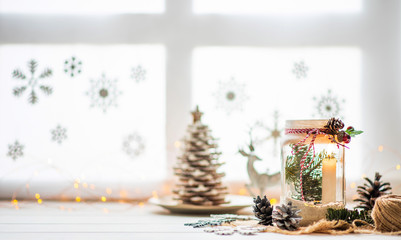Christmas or new year still life with candle lamp and decorative ornaments on rustic white table. Christmas objects with empty copy space for text.