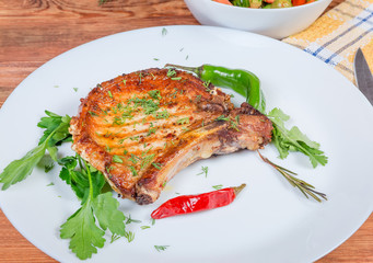 Grilled pork loin chop bone-in on dish close-up