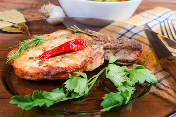 Grilled pork loin chop bone-in on dish close-up