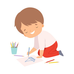 Cute Smiling Boy Sitting on the Floor on His Knees and Drawing Picture with Colorful Pencils, Adorable Young Artist Cartoon Character, Kids Creative Hobby Vector Illustratio