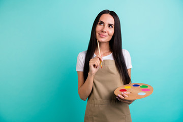 Photo of cheerful positive cute beautfiul woman looking up in a fit of thoughts fantasizing what to...