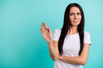 Photo of discontented casual woman gesturing with her palm to stop moving towards her grimacing in...