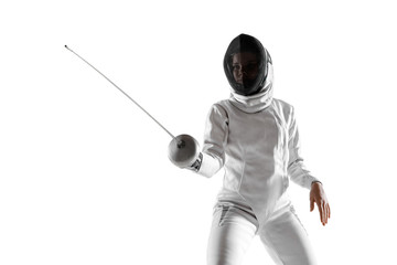 Teen girl in fencing costume with sword in hand isolated on white studio background. Young female...