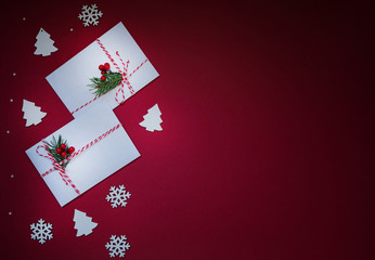 Christmas background for greeting card with Christmas tree branches, decoration and gift on red. Top view with copy space for text.