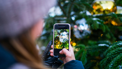 Hand holding screen smart phone on bokeh from christmas tree light can use for design, christmas concept.