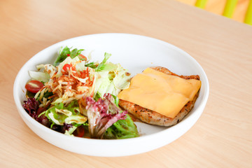 Grilled chicken steak with melted cheese and mixed salad