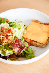 Grilled chicken steak with melted cheese and mixed salad